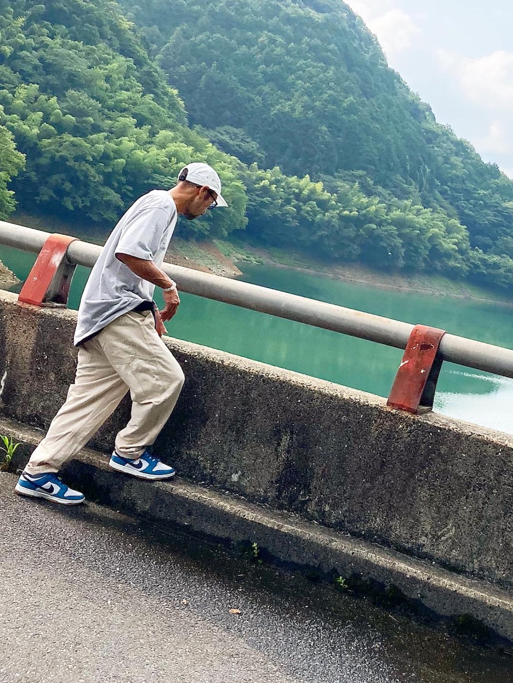 グレー系のTシャツ/カットソー、ベージュ系のチノパンツ、ブルー系のスニーカーを着用したメンズの夏コーディネートの2枚目の写真