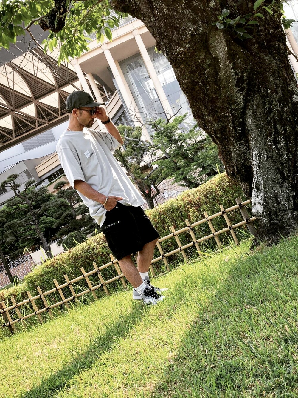 グレー系のTシャツ/カットソー、ブラック系のカーゴパンツ、グレー系のスニーカーを着用したメンズの夏コーディネートの2枚目の写真