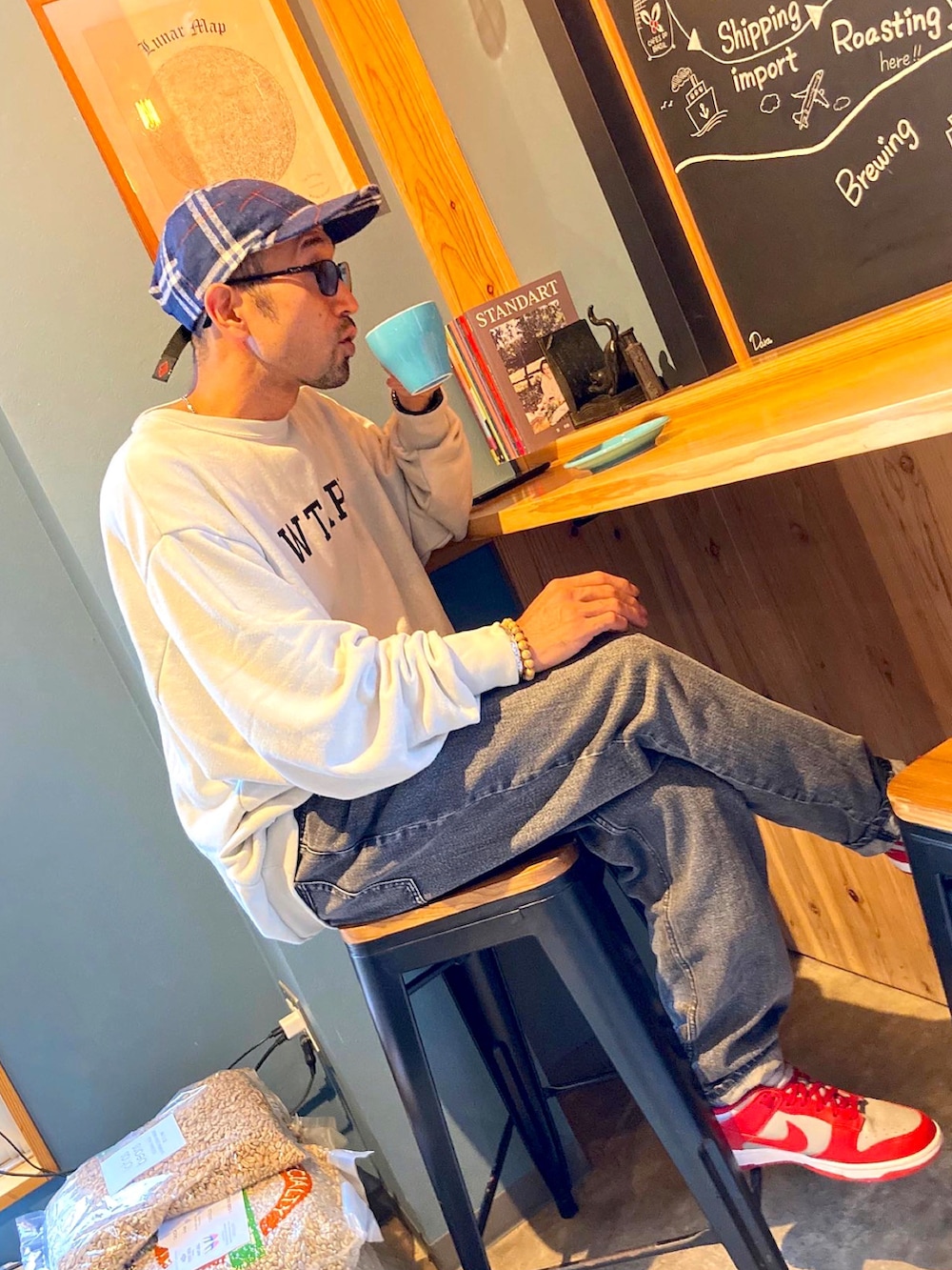 ホワイト系のスウェット、グレー系のデニムパンツ、レッド系のスニーカーを着用したメンズの秋コーディネートの2枚目の写真