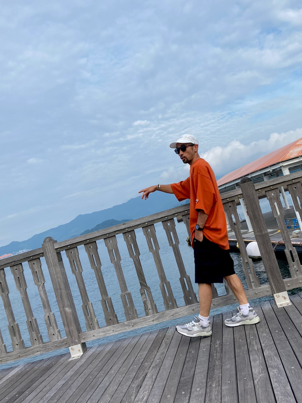 ブラウン系のTシャツ/カットソー、ブラック系のカーゴパンツ、グレー系のスニーカーを着用したメンズの夏コーディネートの3枚目の写真