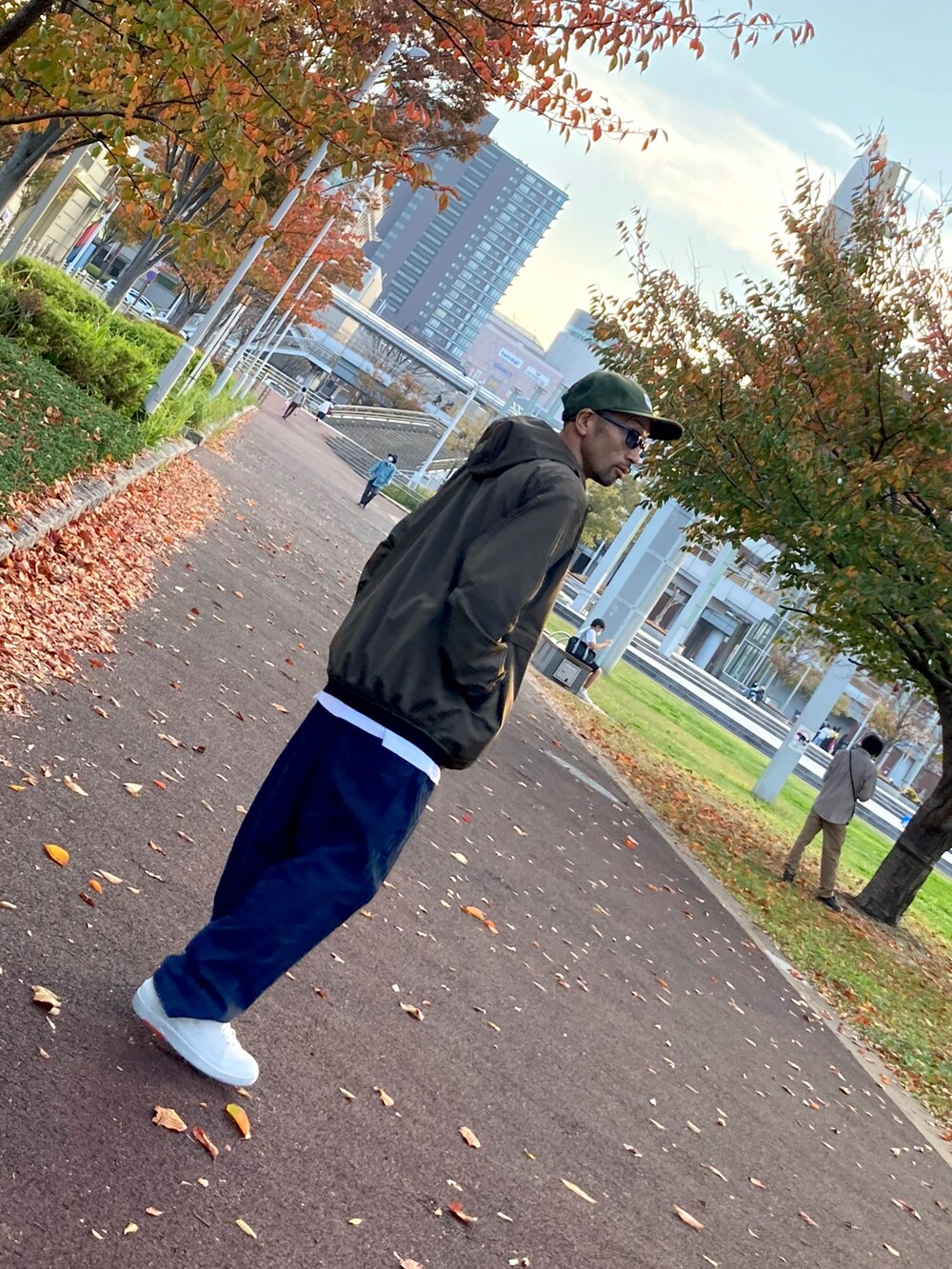 その他のナイロンジャケット、ブルー系のデニムパンツ、ホワイト系のスニーカーを着用したメンズの秋コーディネートの3枚目の写真