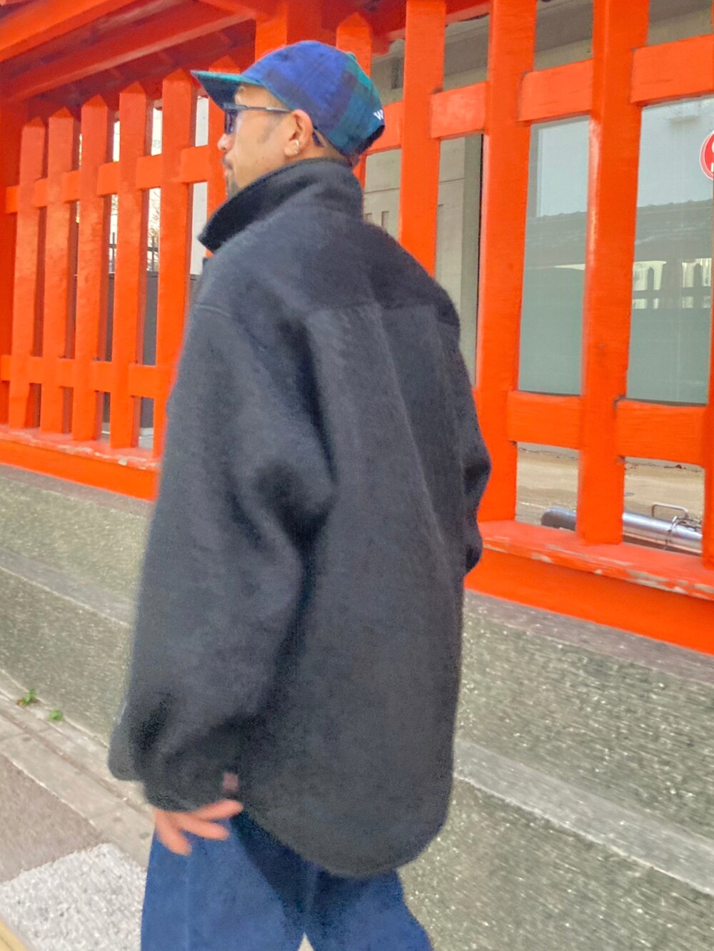 ブラック系のその他アウター、ホワイト系のTシャツ/カットソー、ブルー系のデニムパンツを着用したメンズの秋コーディネートの3枚目の写真