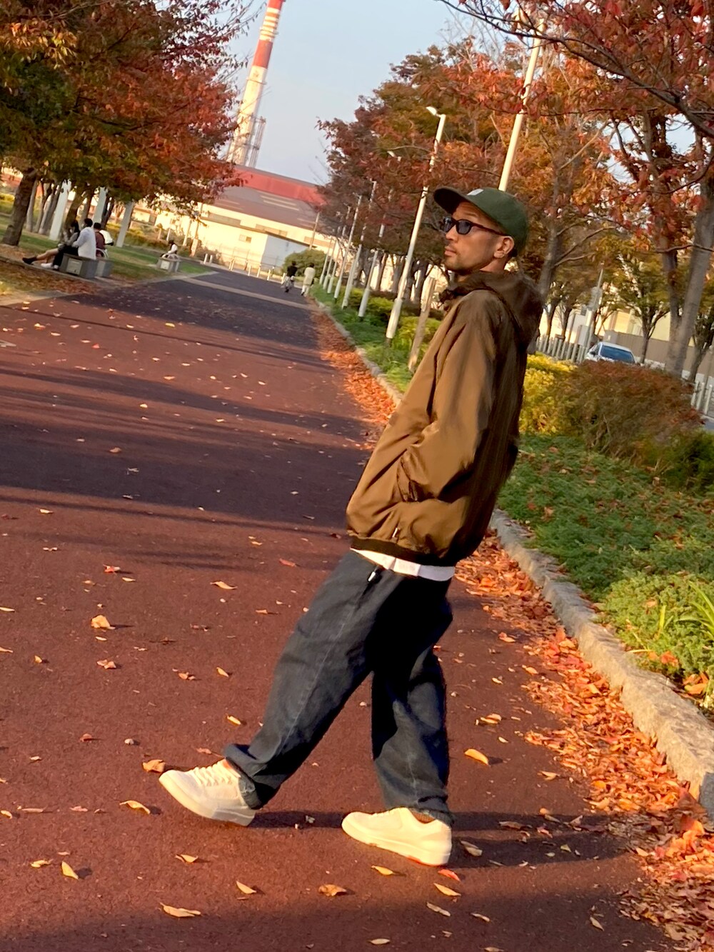 その他のナイロンジャケット、ブルー系のデニムパンツ、ホワイト系のスニーカーを着用したメンズの秋コーディネートの2枚目の写真