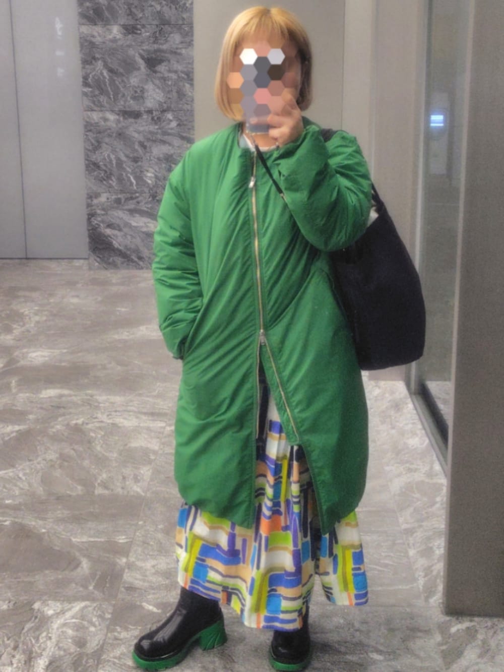 グリーン系のスウェット、その他のスカートを着用したレディースの冬コーディネートの2枚目の写真