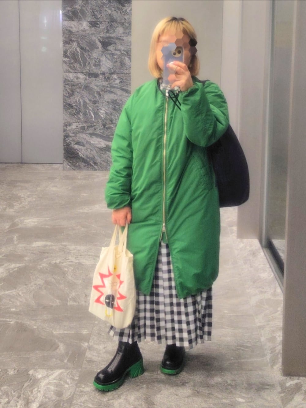 ブラック系のブーツ、ブラック系のシャツワンピース、イエロー系のニット/セーターを着用したレディースの冬コーディネートの2枚目の写真