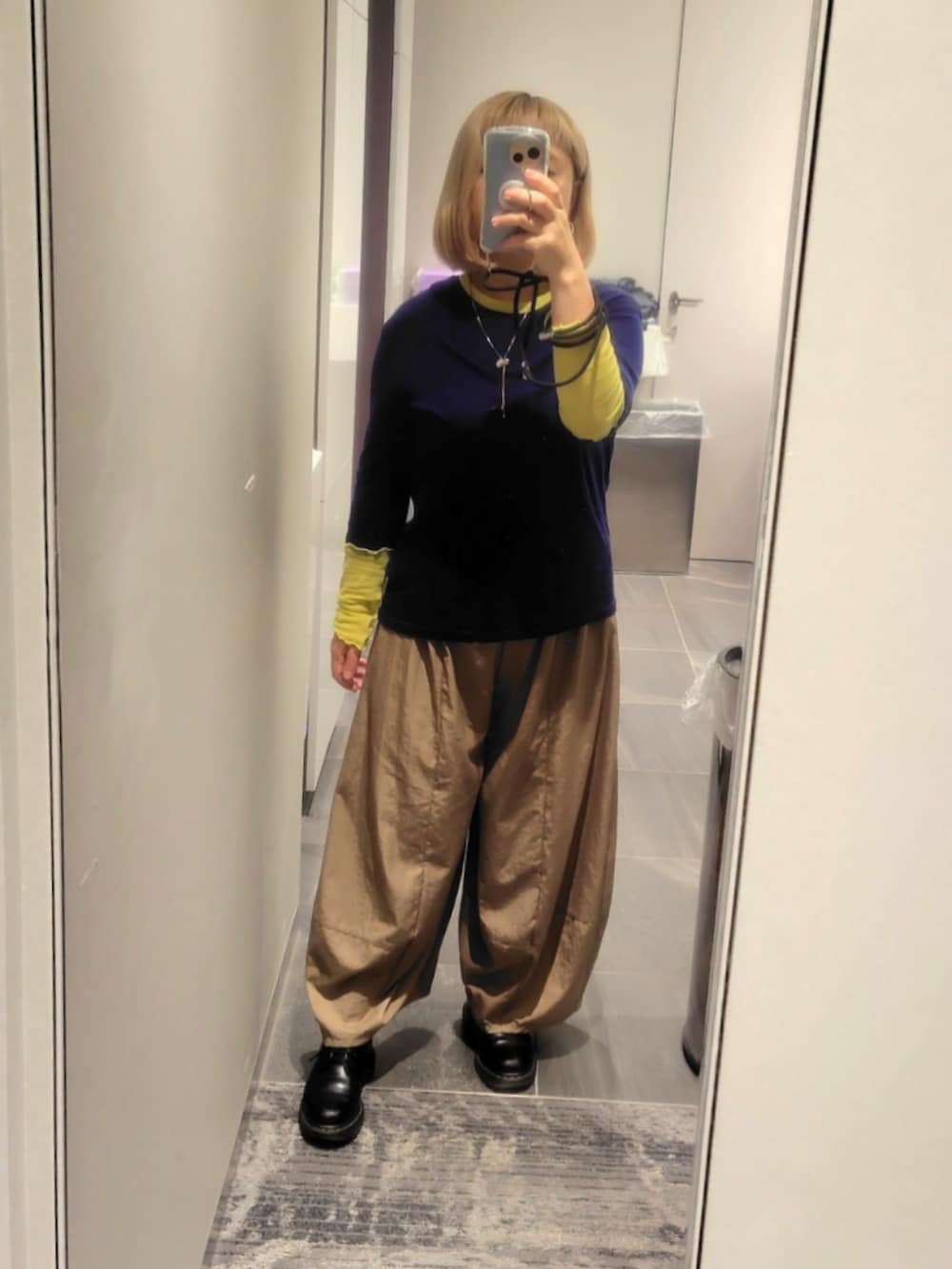 ブラック系のドレスシューズ、ベージュ系のパンツ、ブルー系のニット/セーターを着用したレディースの秋コーディネートの2枚目の写真