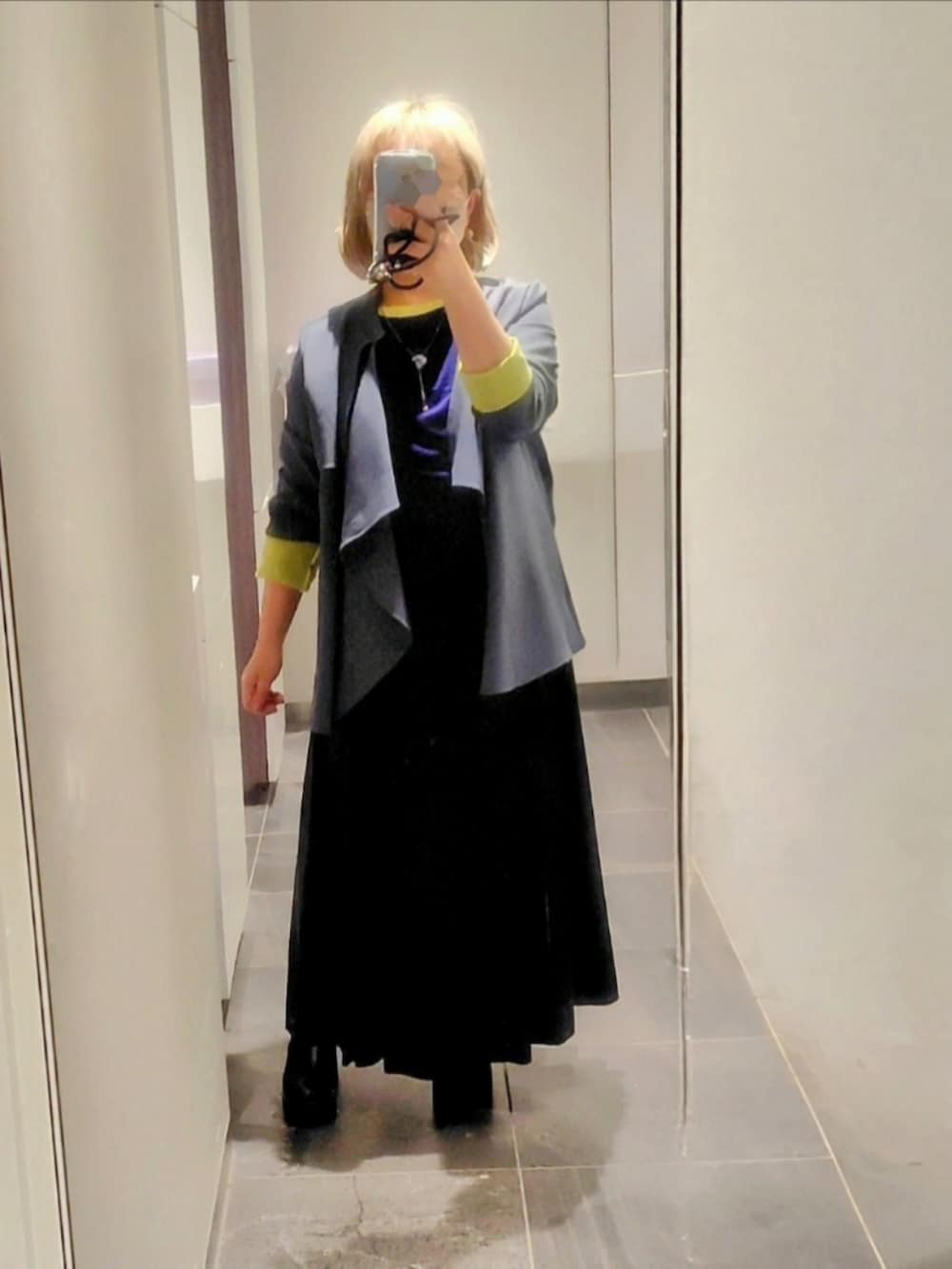 グリーン系のジャケット/アウター、ブラック系のスカート、ブラック系のブーツを着用したレディースの冬コーディネートの2枚目の写真