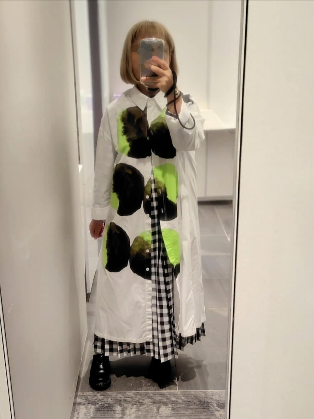 ブルー系のブルゾン、ホワイト系のシャツワンピース、ホワイト系のワンピースを着用したレディースの秋コーディネートの2枚目の写真