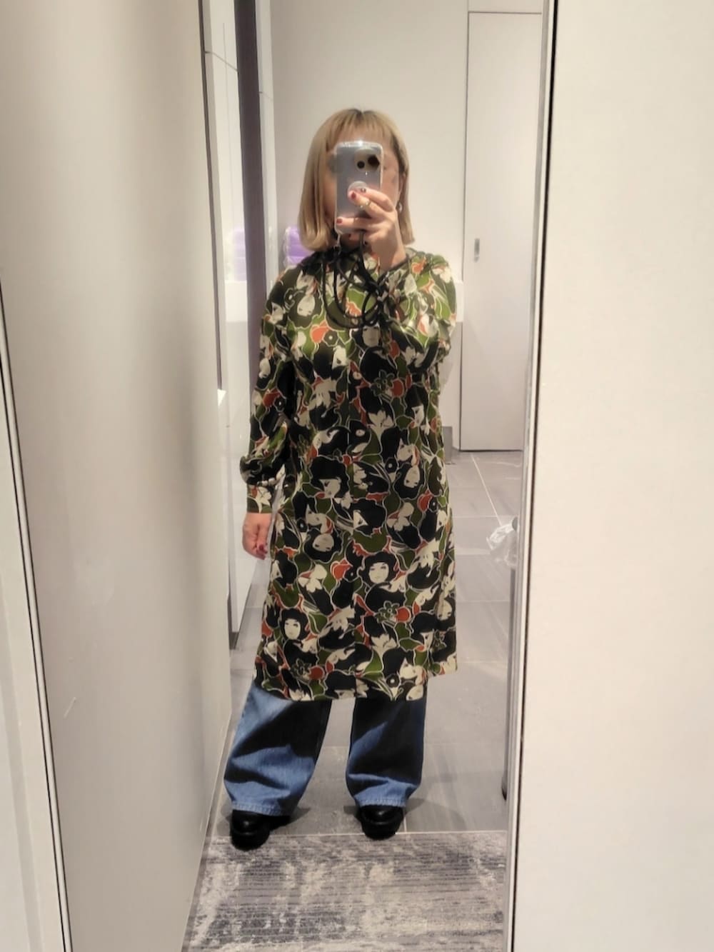 ブラック系のブーツ、ブルー系のデニムパンツ、その他のワンピースを着用したレディースの秋コーディネートの2枚目の写真