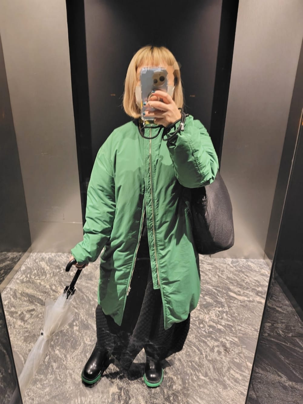 ブラック系のトップス、イエロー系のニット/セーターを着用したレディースの冬コーディネートの2枚目の写真