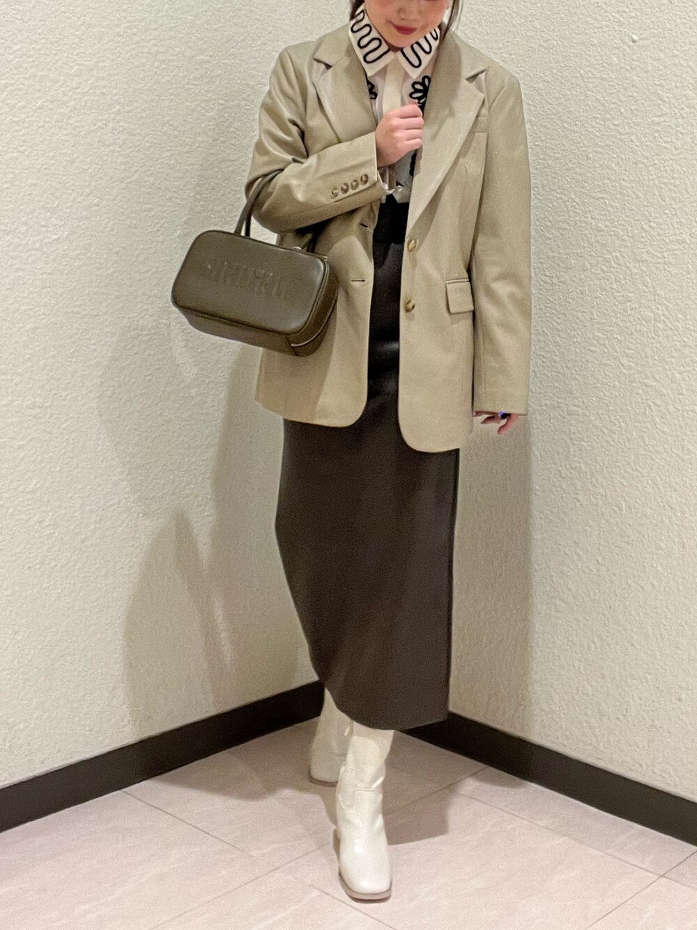 ベージュ系のテーラードジャケット、ホワイト系のシャツ/ブラウス、イエロー系のボストンバッグを着用したレディースの秋コーディネートの3枚目の写真