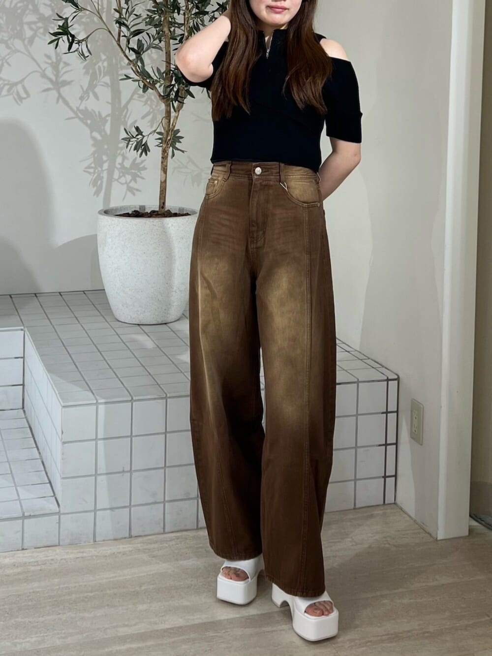 ホワイト系のサンダル、ブラウン系のデニムパンツ、ブラック系のニット/セーターを着用したレディースの夏コーディネートの5枚目の写真