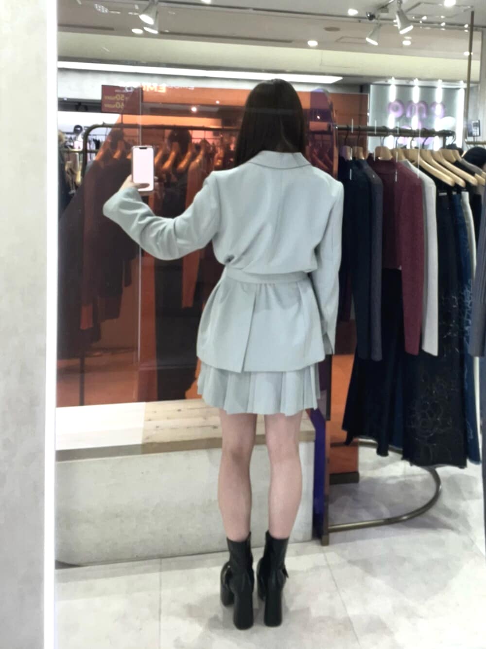 ブラック系のブーツ、グリーン系のテーラードジャケット、グリーン系のスカートを着用したレディースの冬コーディネートの3枚目の写真