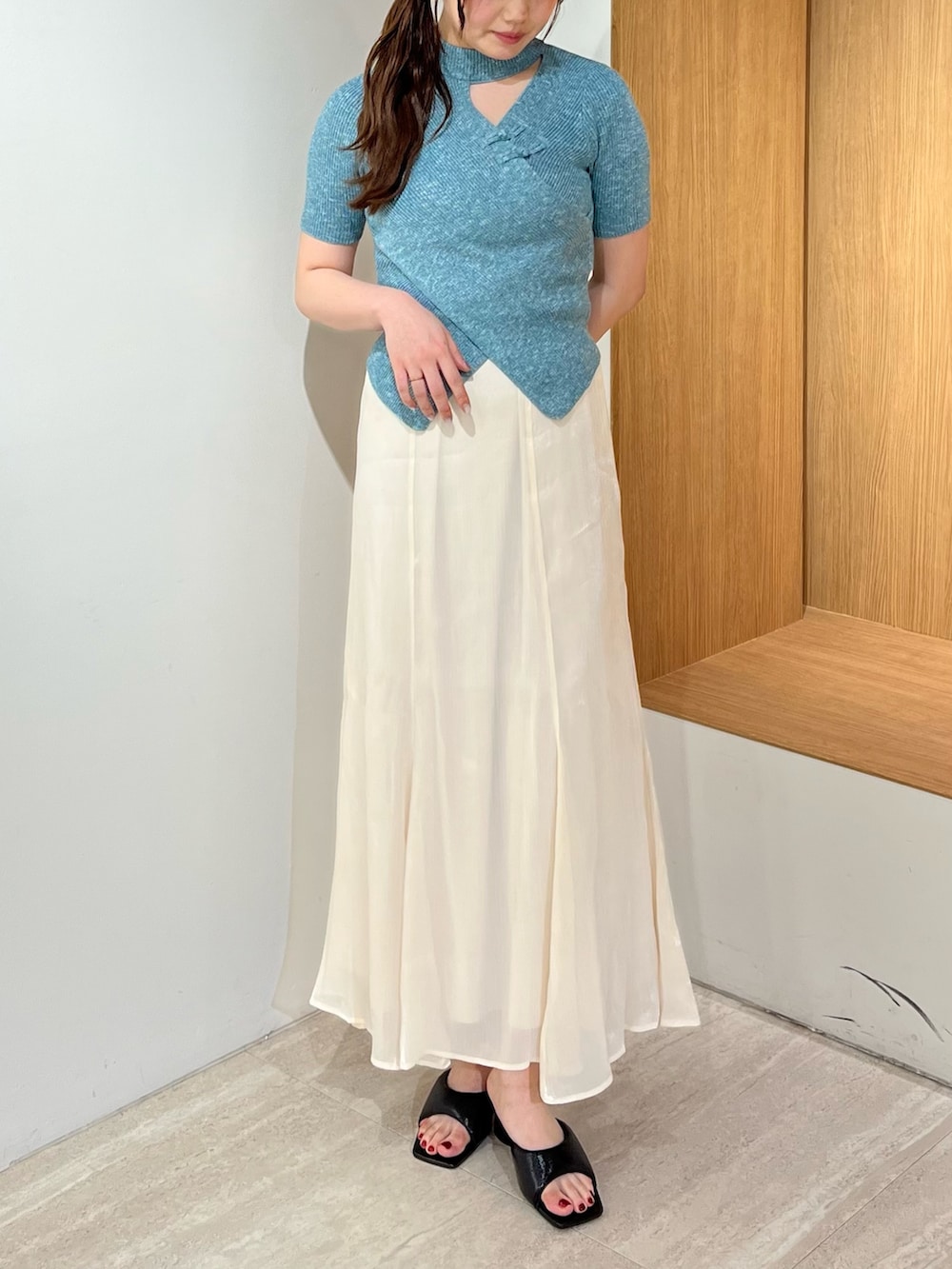 ブラック系のパンプス、ホワイト系のスカート、ブルー系のニット/セーターを着用したレディースの夏コーディネートの6枚目の写真