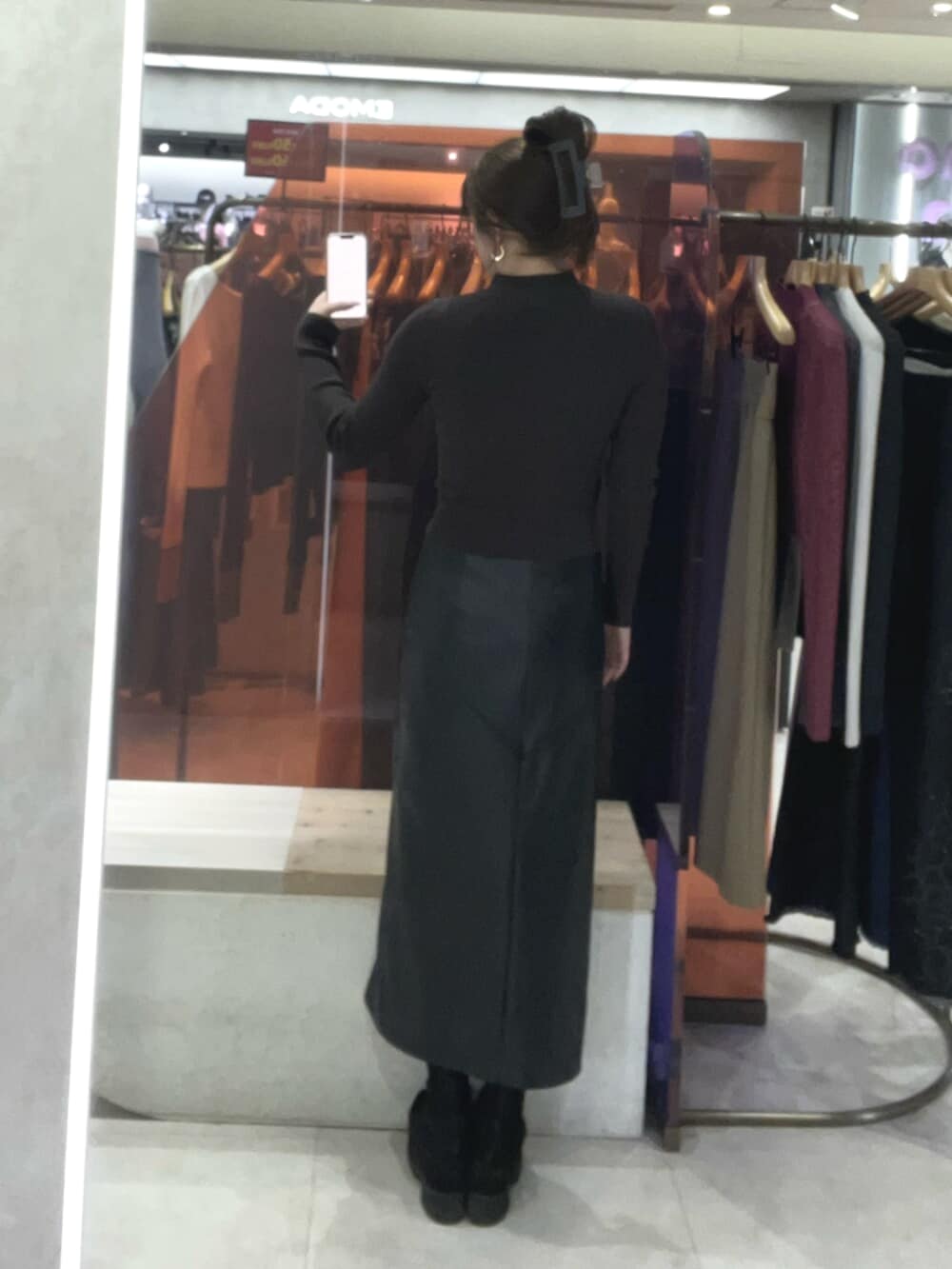 ブラック系のブーツ、ブラック系のスカート、その他のニット/セーターを着用したレディースの冬コーディネートの3枚目の写真