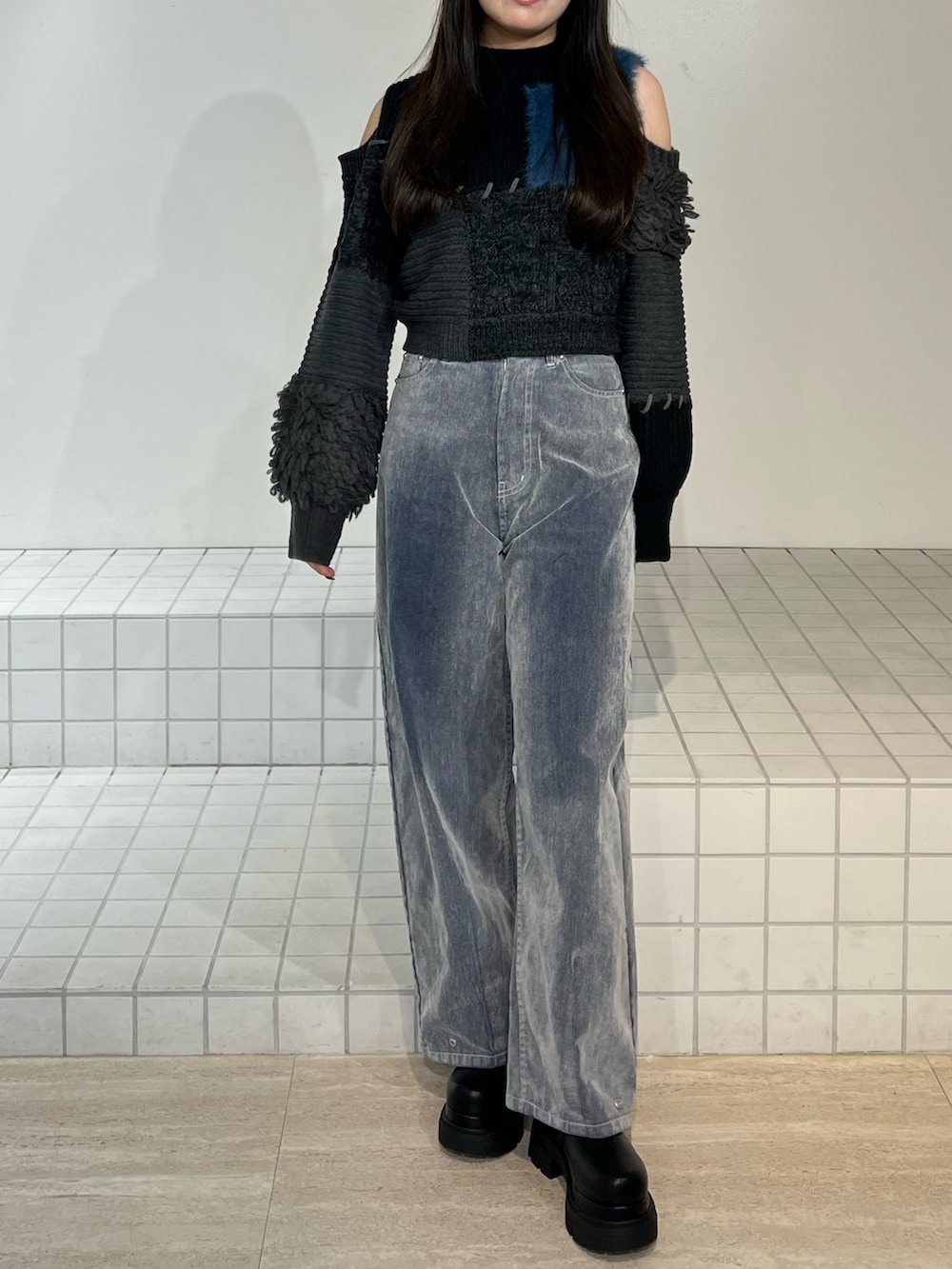 ブラック系のブーツ、グレー系のデニムパンツ、ブラック系のニット/セーターを着用したレディースの秋コーディネートの6枚目の写真