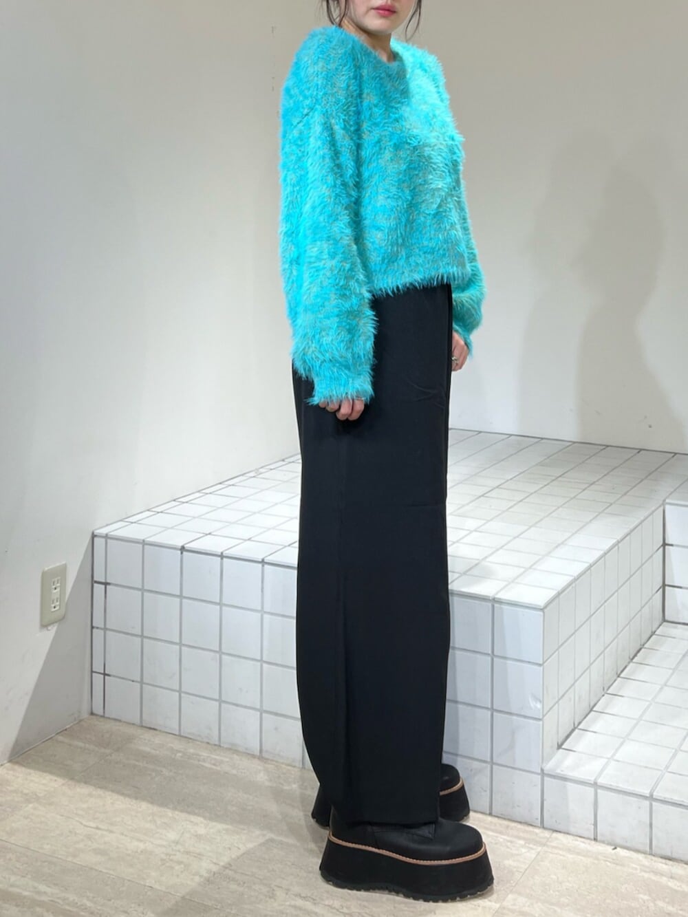 ブルー系のニット/セーター、ブラック系のブーツ、ブラック系のその他パンツを着用したレディースの冬コーディネートの5枚目の写真