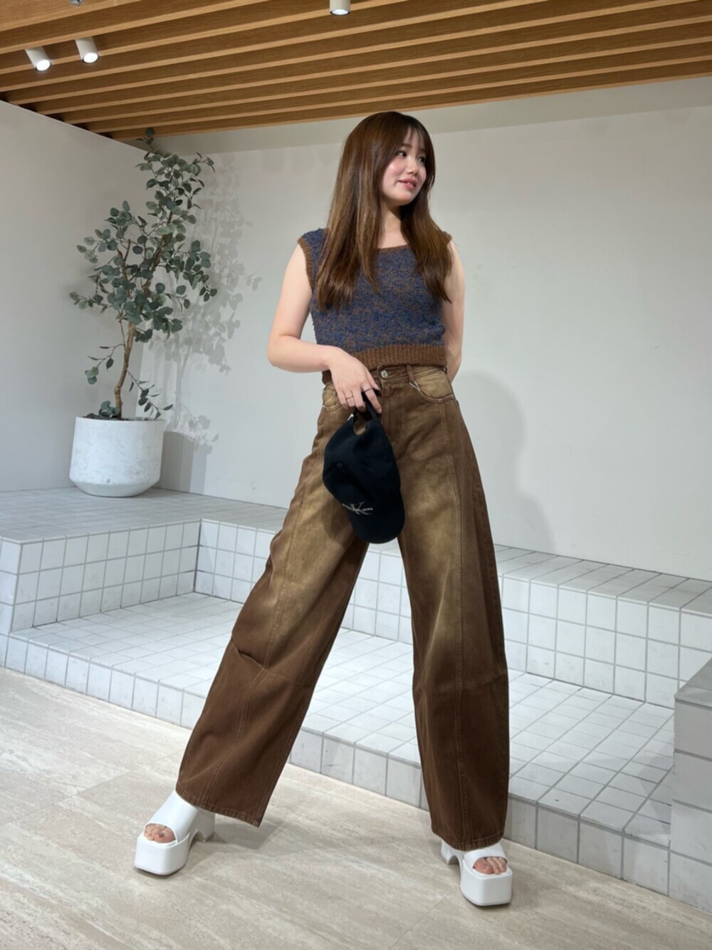 ホワイト系のサンダル、ブラウン系のデニムパンツ、ブラウン系のニット/セーターを着用したレディースの夏コーディネートの6枚目の写真