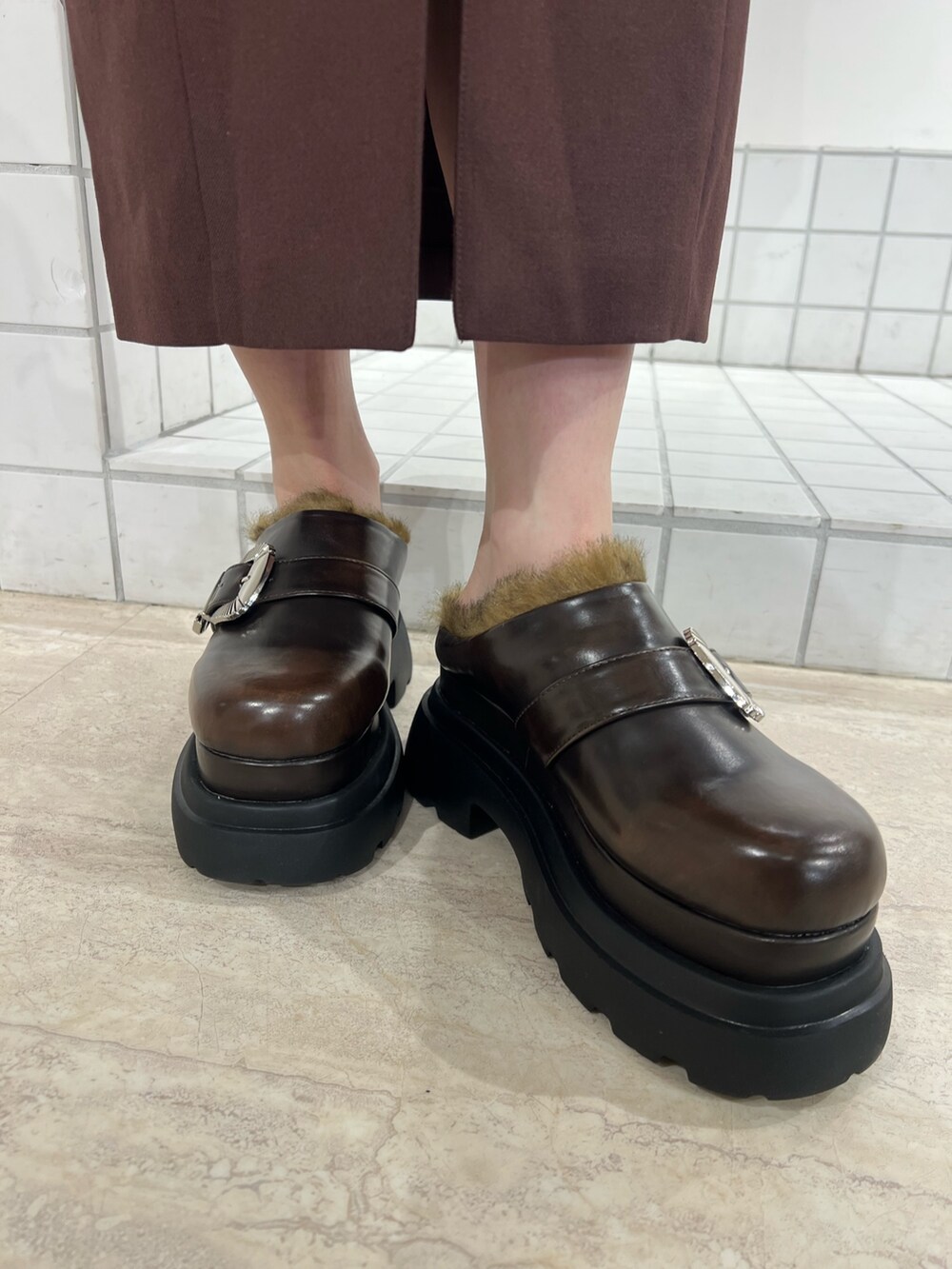 ブラック系のサンダル、ブラック系のジャンパースカート、ブラック系のニット/セーターを着用したレディースの秋コーディネートの5枚目の写真