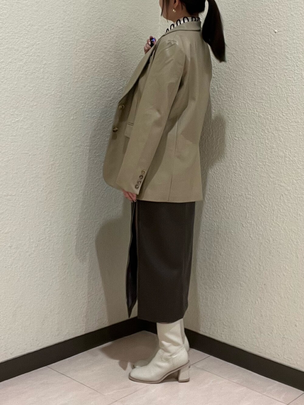 ベージュ系のテーラードジャケット、ホワイト系のシャツ/ブラウス、イエロー系のボストンバッグを着用したレディースの秋コーディネートの4枚目の写真