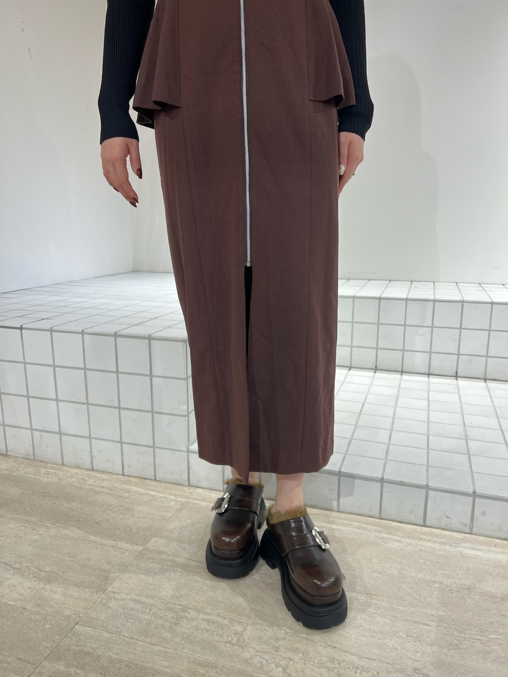 ブラック系のサンダル、ブラック系のジャンパースカート、ブラック系のニット/セーターを着用したレディースの秋コーディネートの4枚目の写真