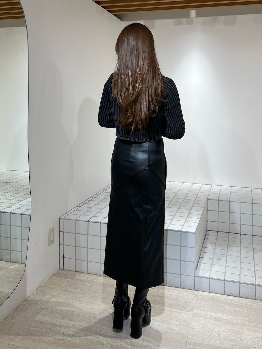 ブラック系のブーツ、ブラック系のニット/セーター、ブラック系のスカートを着用したレディースの冬コーディネートの4枚目の写真
