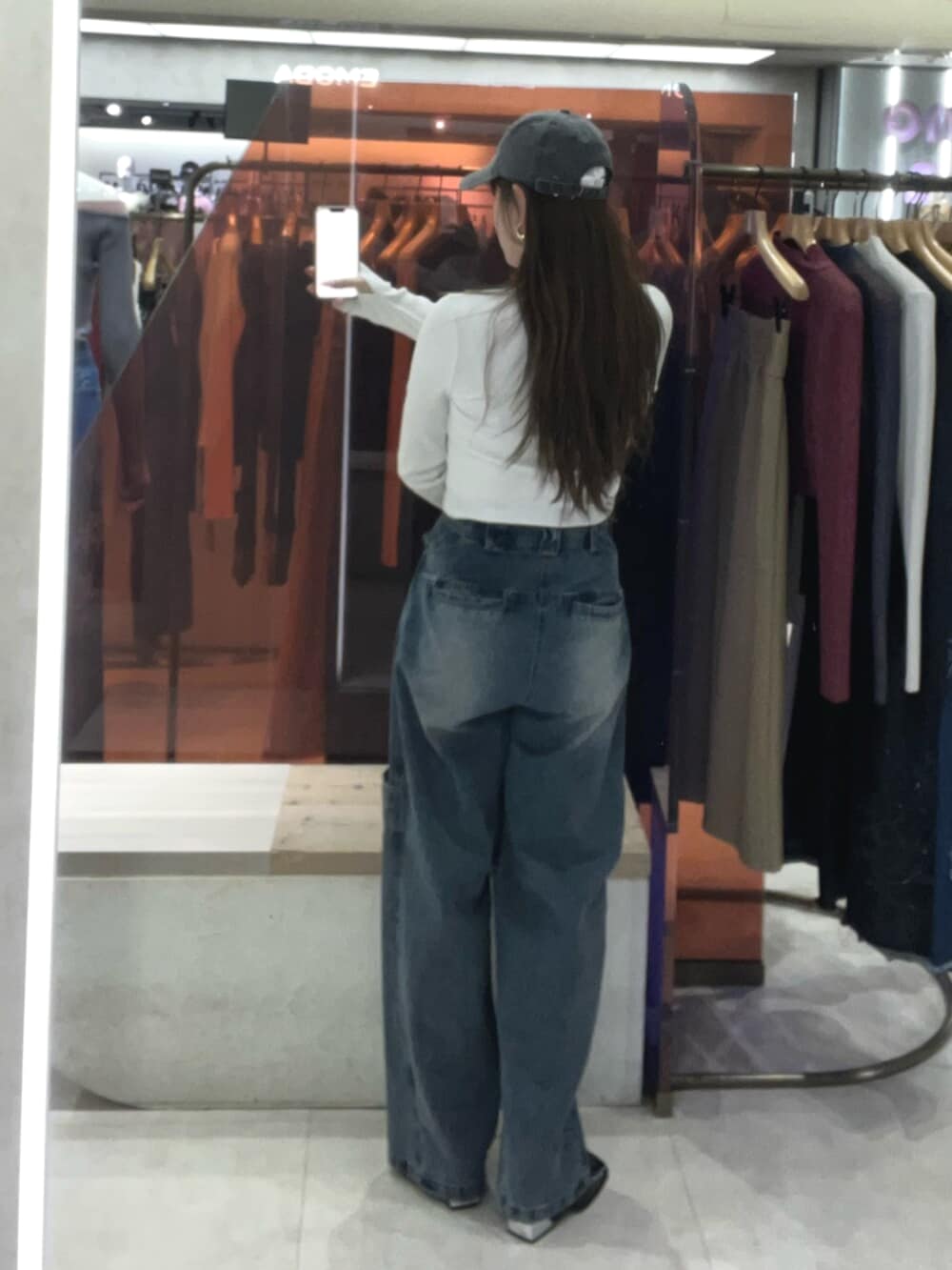 イエロー系のTシャツ/カットソー、ブルー系のデニムパンツ、ブラック系のパンプスを着用したレディースの冬コーディネートの3枚目の写真