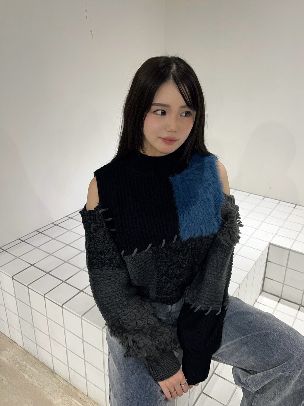 ブラック系のブーツ、グレー系のデニムパンツ、ブラック系のニット/セーターを着用したレディースの秋コーディネートの5枚目の写真