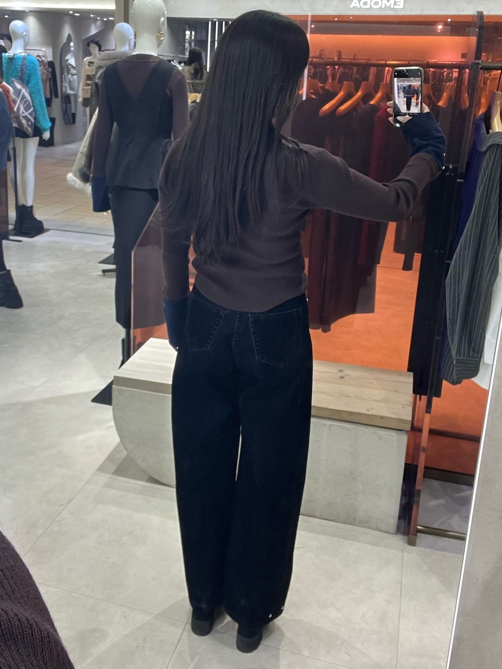 ブラック系のブーツ、ブラウン系のニット/セーター、ブラック系のデニムパンツを着用したレディースの秋コーディネートの5枚目の写真