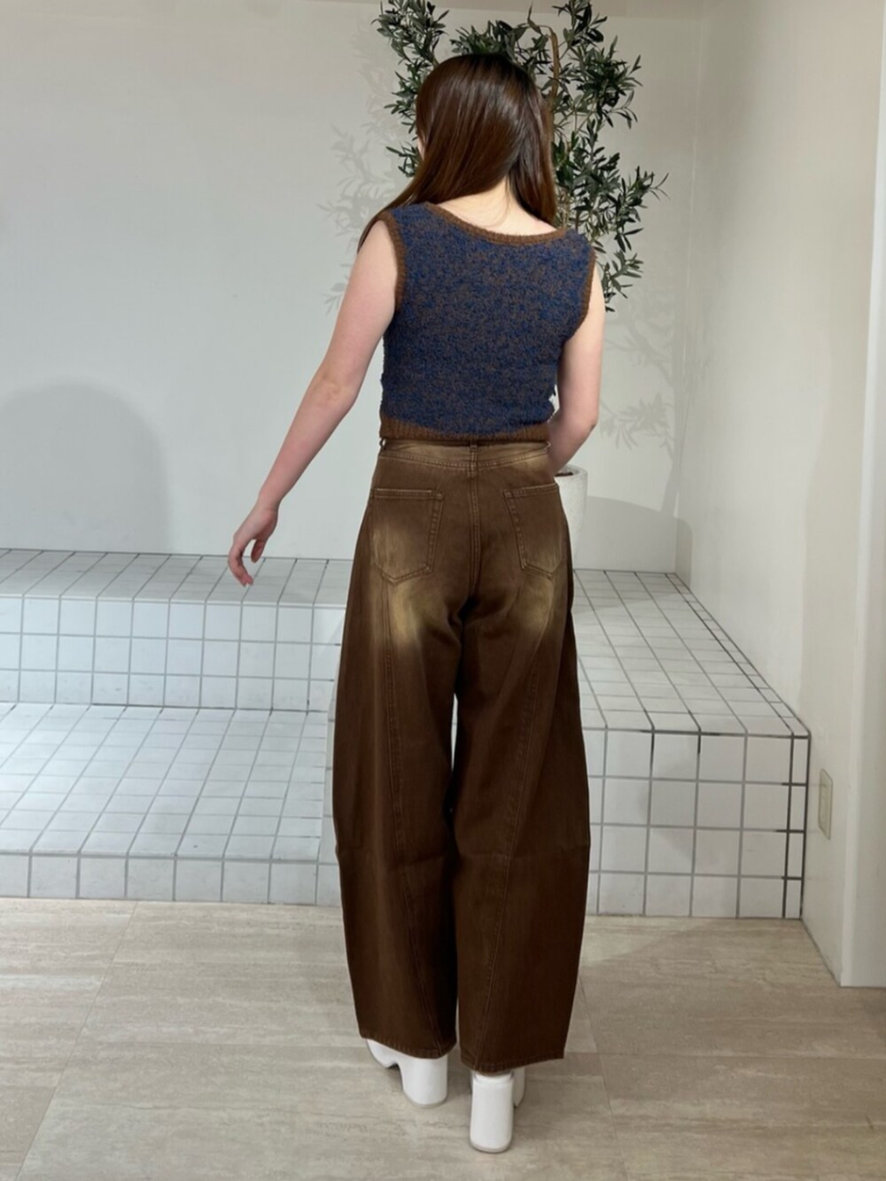 ホワイト系のサンダル、ブラウン系のデニムパンツ、ブラウン系のニット/セーターを着用したレディースの夏コーディネートの3枚目の写真