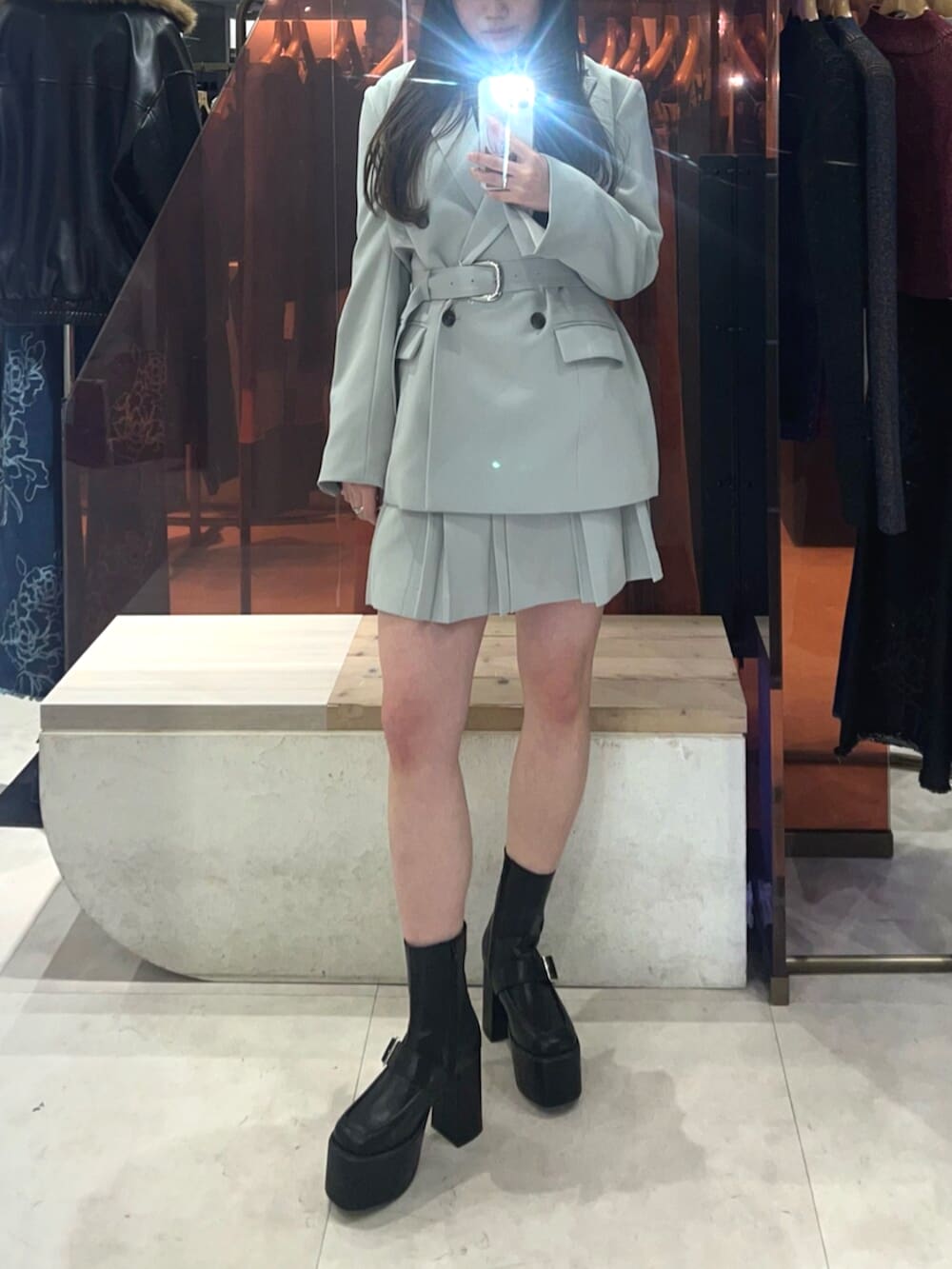 ブラック系のブーツ、グリーン系のテーラードジャケット、グリーン系のスカートを着用したレディースの冬コーディネートの5枚目の写真