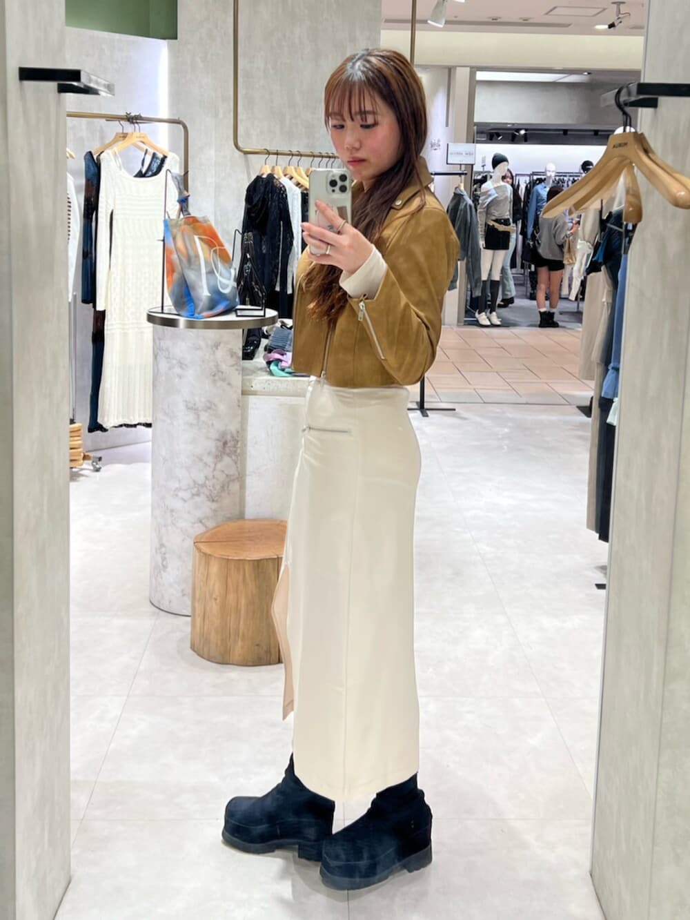 ブラック系のブーツ、ホワイト系のTシャツ/カットソー、イエロー系のライダースジャケットを着用したレディースの春コーディネートの4枚目の写真