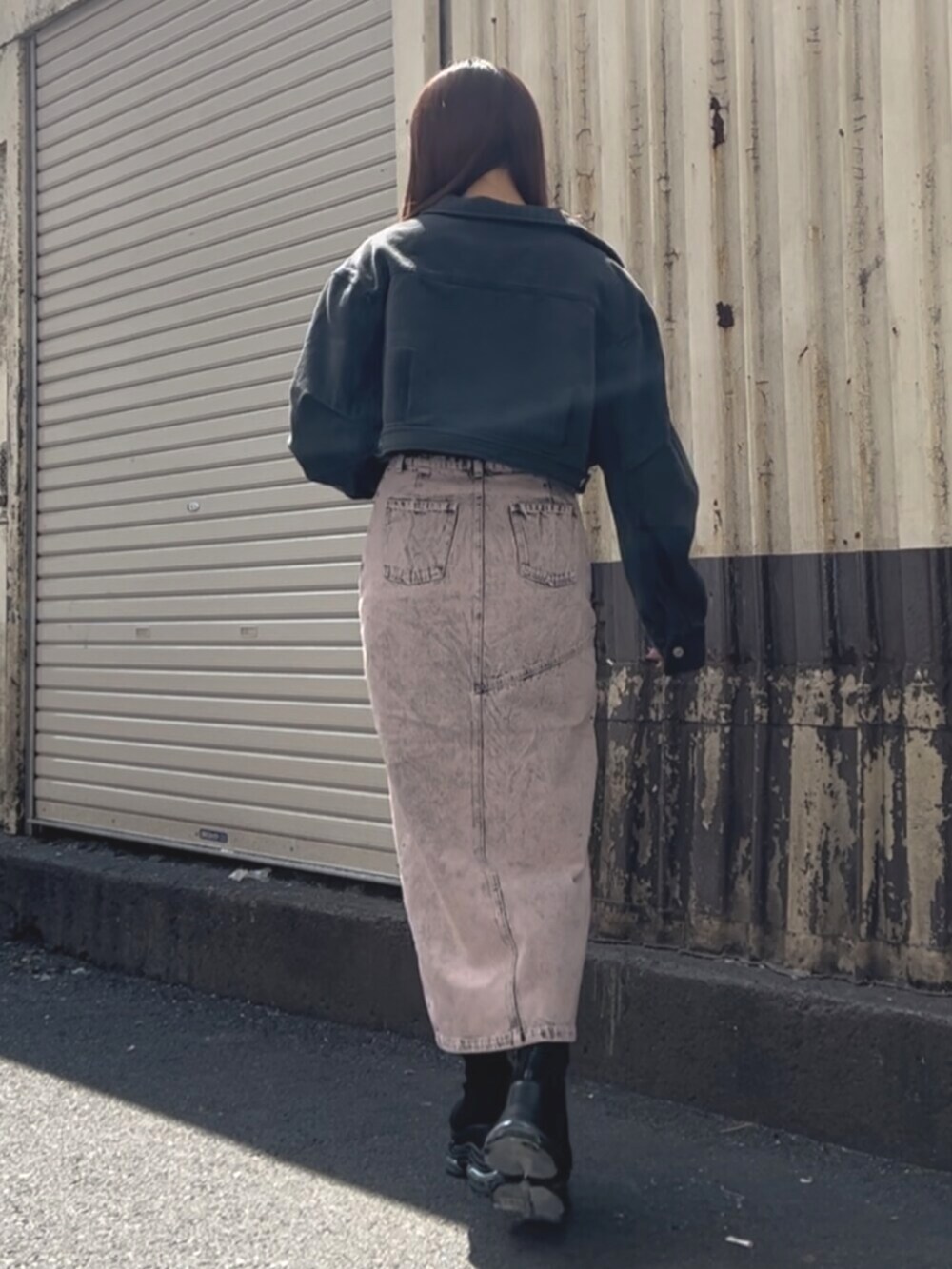 ブラック系のブーツ、ブラック系のデニムジャケット、ピンク系のデニムスカートを着用したレディースの春コーディネートの3枚目の写真