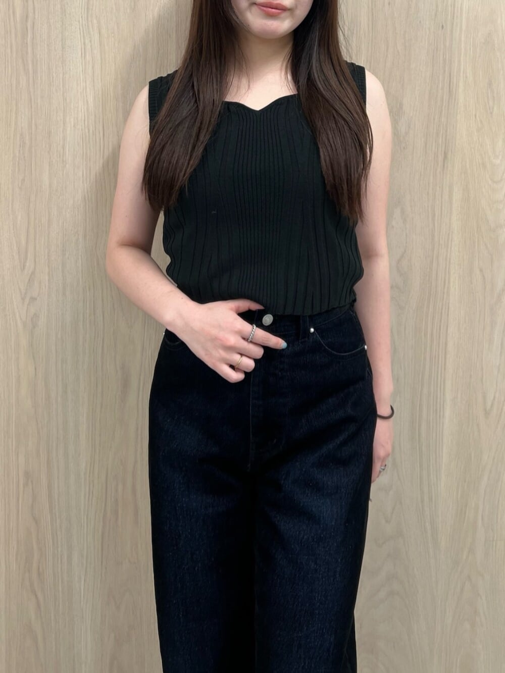 ホワイト系のタンクトップ、ブラウン系のブーツ、ブラック系のデニムパンツを着用したレディースの夏コーディネートの4枚目の写真