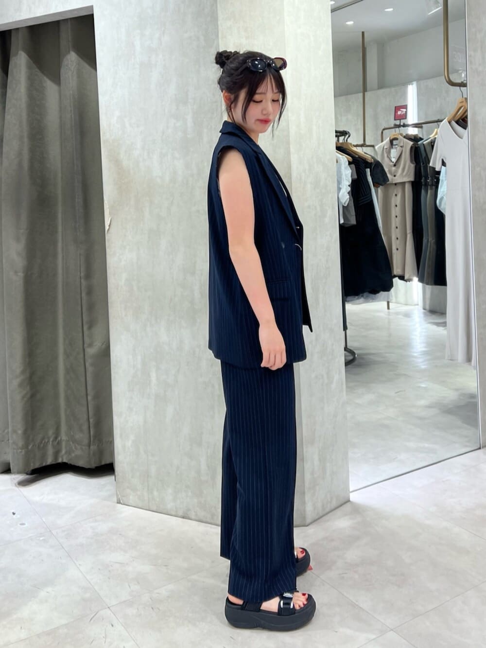 ホワイト系のタンクトップ、ブラック系のその他パンツ、ブルー系のベストを着用したレディースの夏コーディネートの2枚目の写真