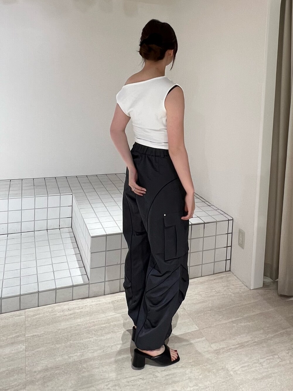 ブラック系のパンプス、グレー系のカーゴパンツ、ホワイト系のTシャツ/カットソーを着用したレディースの夏コーディネートの2枚目の写真