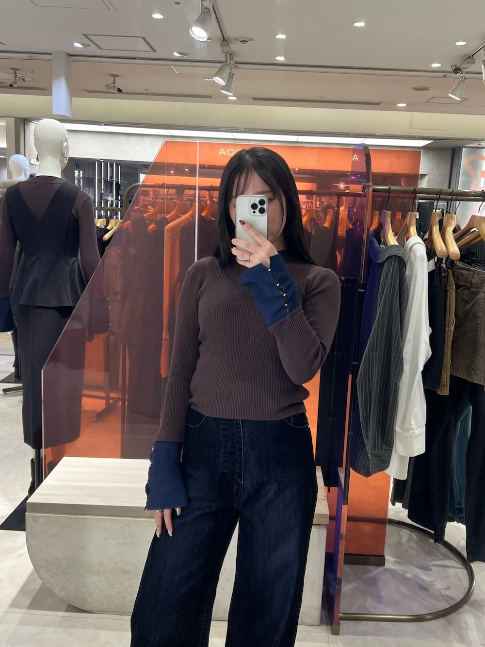 ブラック系のブーツ、ブラウン系のニット/セーター、ブラック系のデニムパンツを着用したレディースの秋コーディネートの3枚目の写真