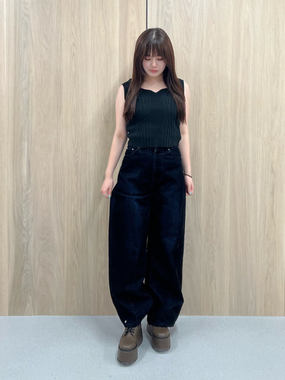 ホワイト系のタンクトップ、ブラウン系のブーツ、ブラック系のデニムパンツを着用したレディースの夏コーディネートの6枚目の写真