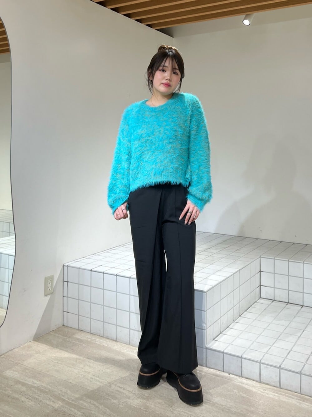 ブルー系のニット/セーター、ブラック系のブーツ、ブラック系のその他パンツを着用したレディースの冬コーディネートの6枚目の写真