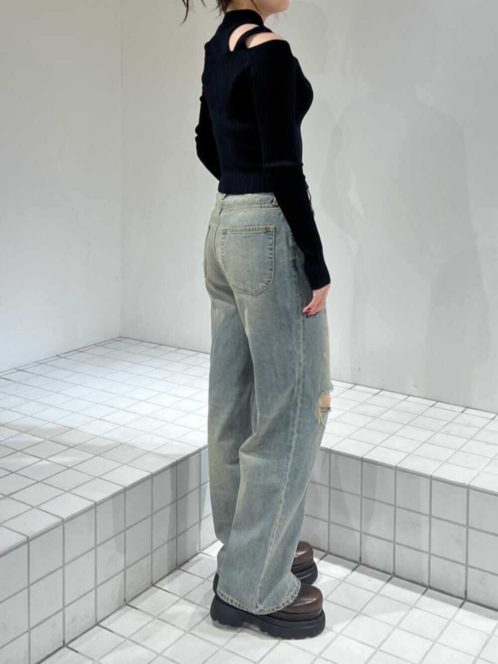 ブラック系のサンダル、ブルー系のデニムパンツ、ブラック系のニット/セーターを着用したレディースの秋コーディネートの2枚目の写真