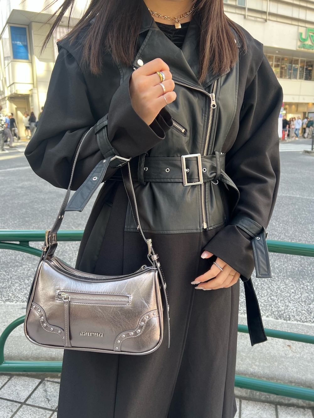 ブラック系のその他パンツ、ブラック系のトレンチコート、ゴールド系のハンドバッグを着用したレディースの秋コーディネートの5枚目の写真