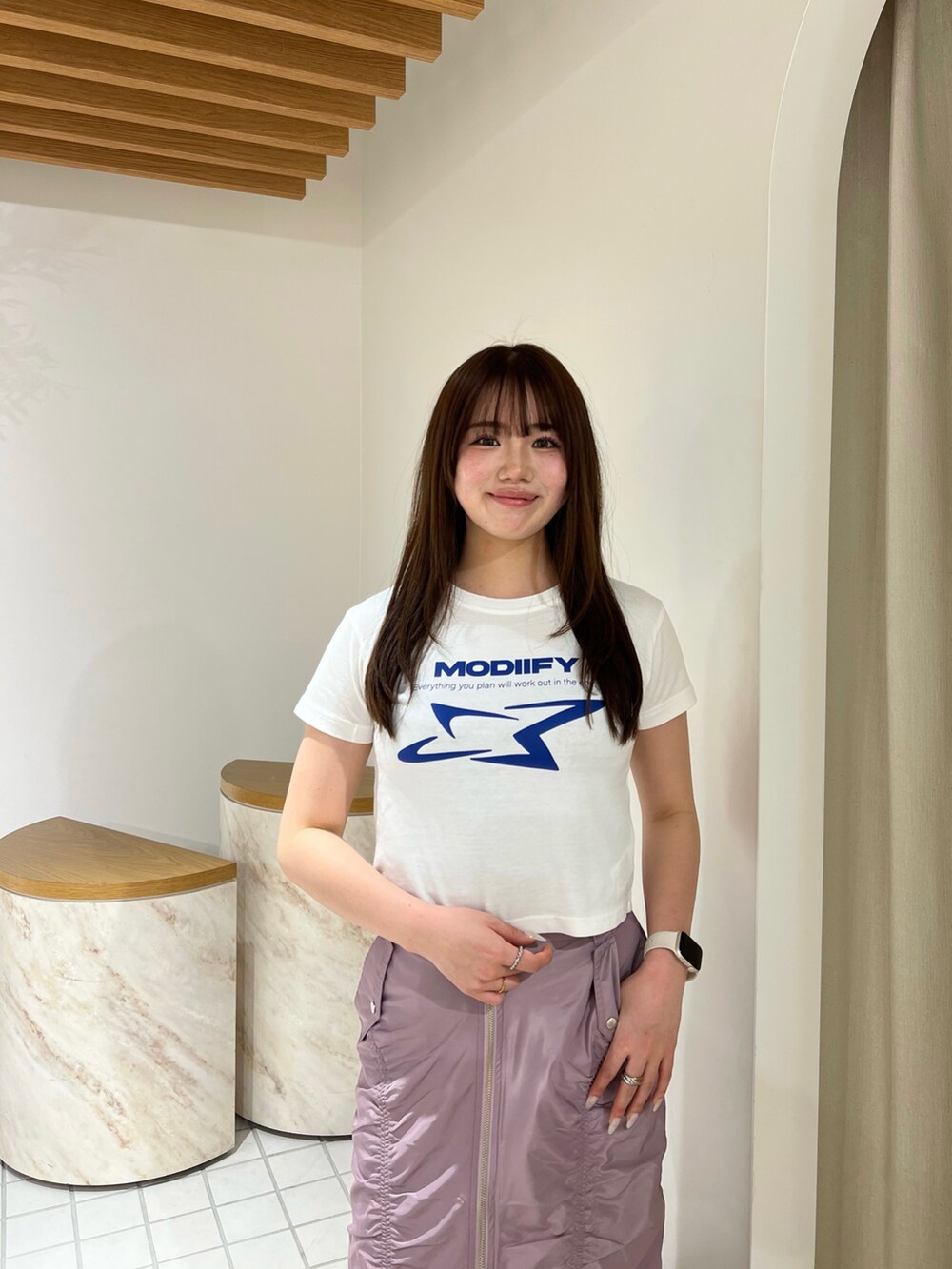 ピンク系のスカート、ホワイト系のTシャツ/カットソー、ブラック系のサンダルを着用したレディースの春コーディネートの4枚目の写真