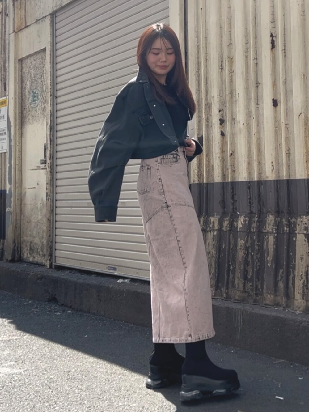 ブラック系のブーツ、ブラック系のデニムジャケット、ピンク系のデニムスカートを着用したレディースの春コーディネートの2枚目の写真