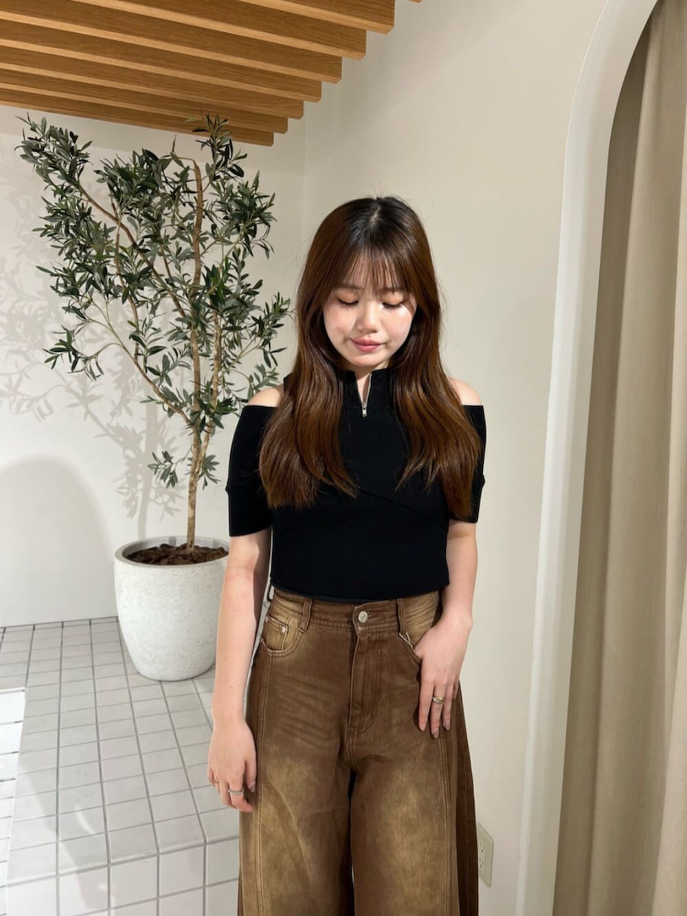 ホワイト系のサンダル、ブラウン系のデニムパンツ、ブラック系のニット/セーターを着用したレディースの夏コーディネートの4枚目の写真