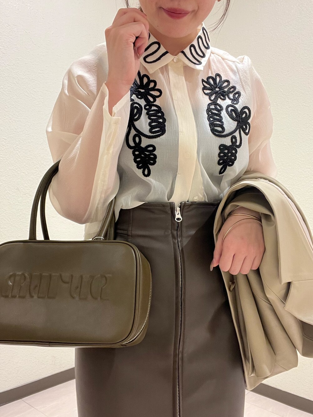 ベージュ系のテーラードジャケット、ホワイト系のシャツ/ブラウス、イエロー系のボストンバッグを着用したレディースの秋コーディネートの2枚目の写真