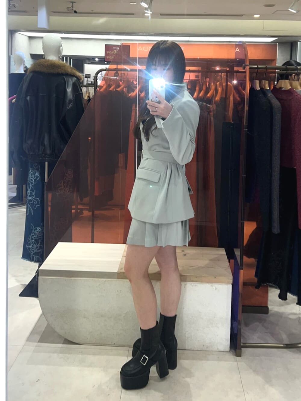 ブラック系のブーツ、グリーン系のテーラードジャケット、グリーン系のスカートを着用したレディースの冬コーディネートの2枚目の写真