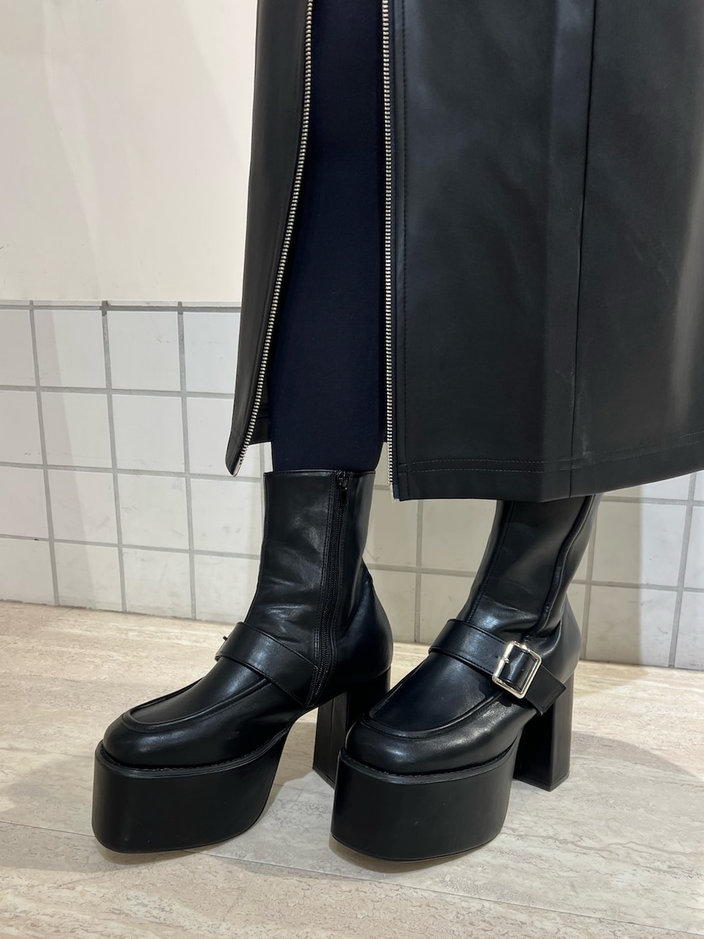 ブラック系のブーツ、ブラック系のニット/セーター、ブラック系のスカートを着用したレディースの冬コーディネートの5枚目の写真