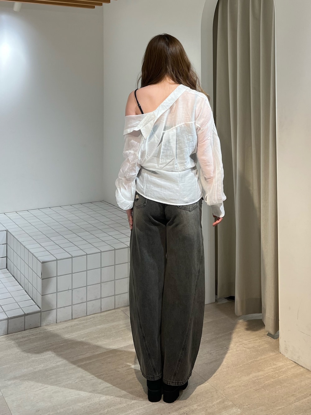 ブラック系のブーツ、グレー系のデニムパンツ、ブラック系のキャミソールを着用したレディースの春コーディネートの4枚目の写真
