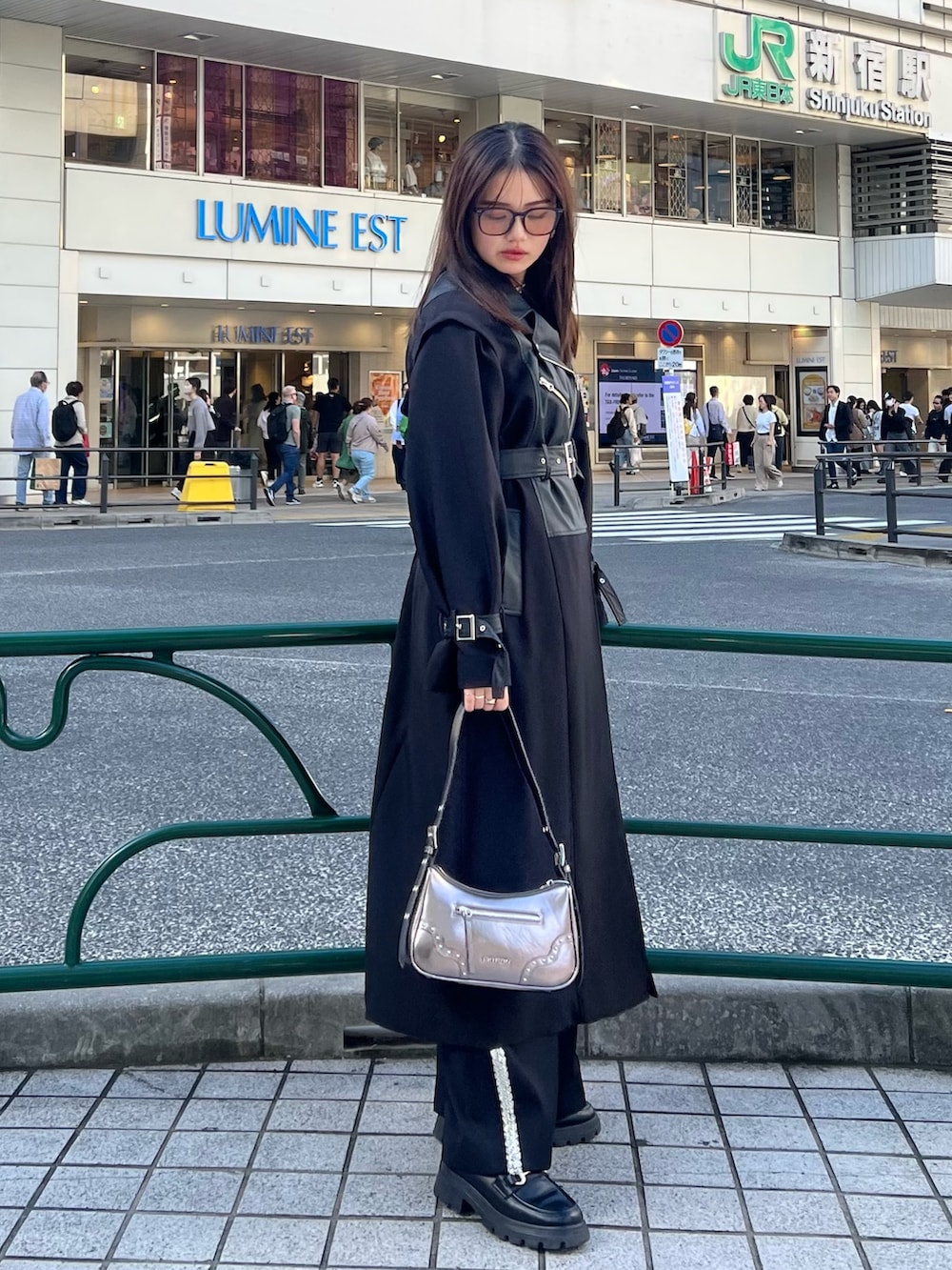 ブラック系のその他パンツ、ブラック系のトレンチコート、ゴールド系のハンドバッグを着用したレディースの秋コーディネートの2枚目の写真