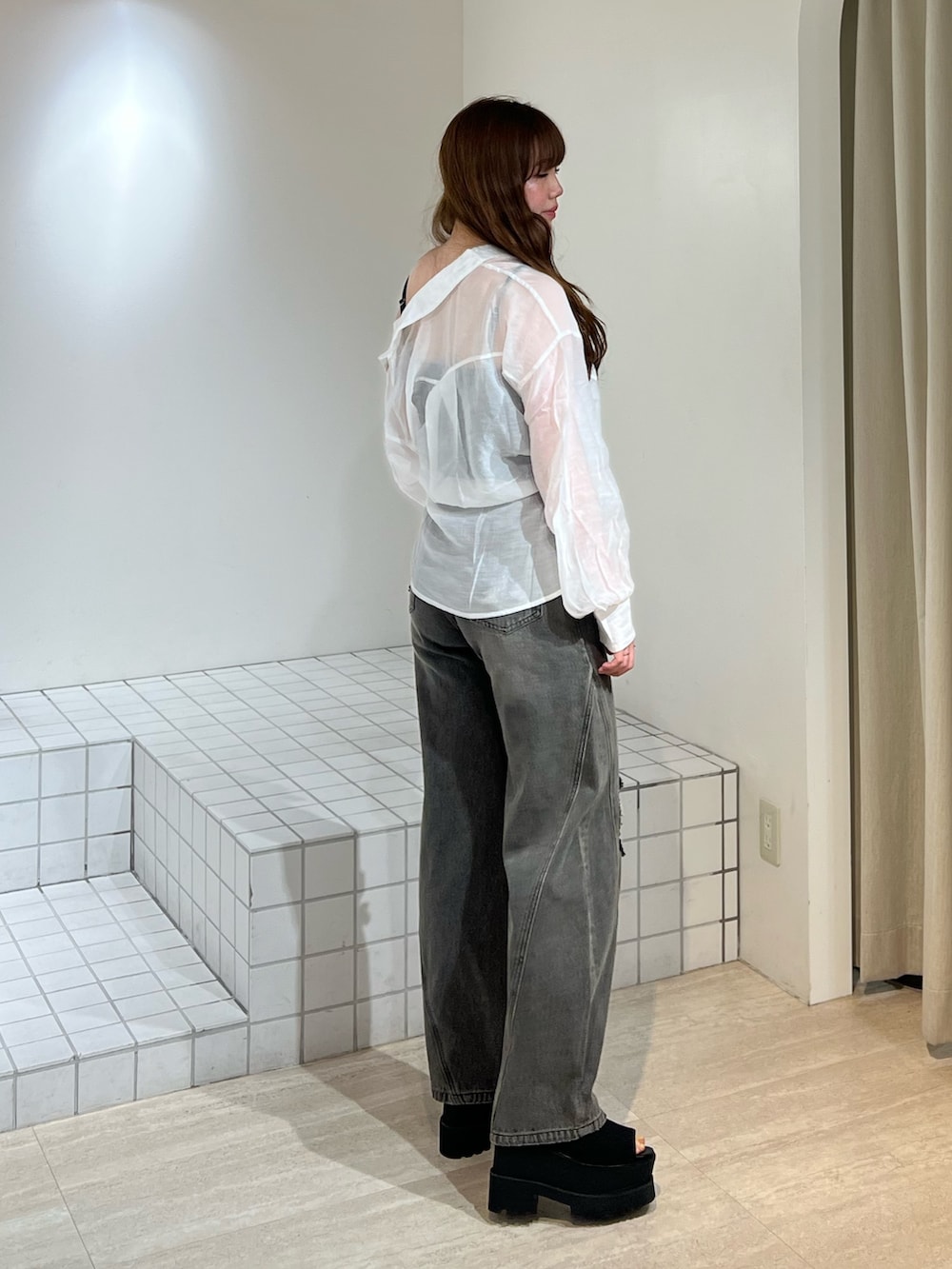 ブラック系のブーツ、グレー系のデニムパンツ、ブラック系のキャミソールを着用したレディースの春コーディネートの3枚目の写真
